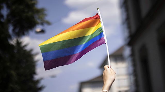 A person holds a rainbow flag  during the Zurich Pride parade in Zurich, Switzerland, Saturday, June 17, 2023. (Michael Buholzer/Keystone via AP)